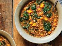 Lentil and Spinach Soup in a beige ceramic bowl on a wooden tabletop
