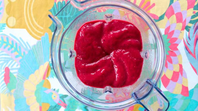 blender Top down view of smoothie in a blender on a colorful tablecloth